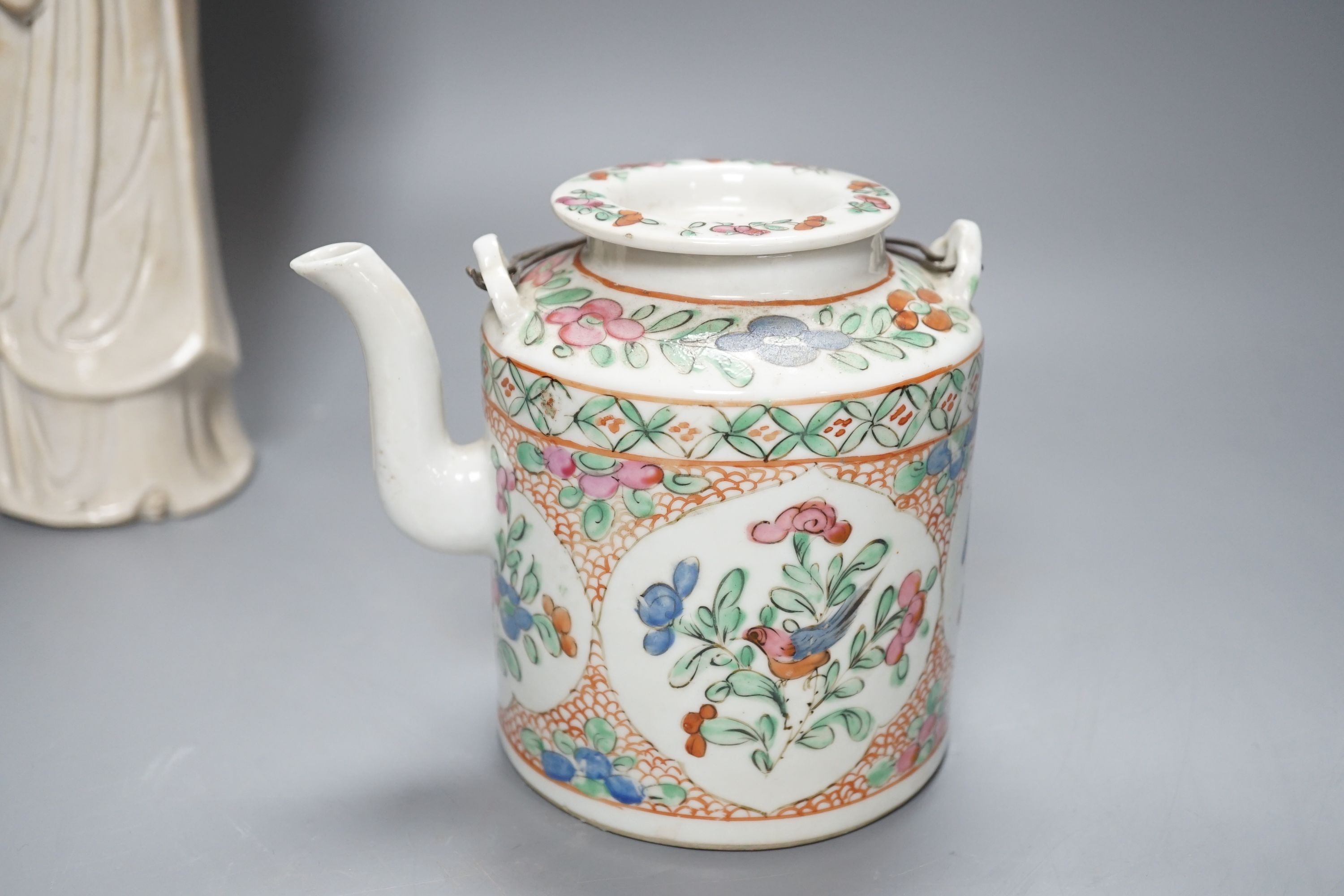 A Chinese blanc de chin figure of a lady with a bird, 37cm, together with a famille rose teapot, a yixing style teapot, blue and white jar and cover and a pale celadon ground ‘ox head’ libation cup